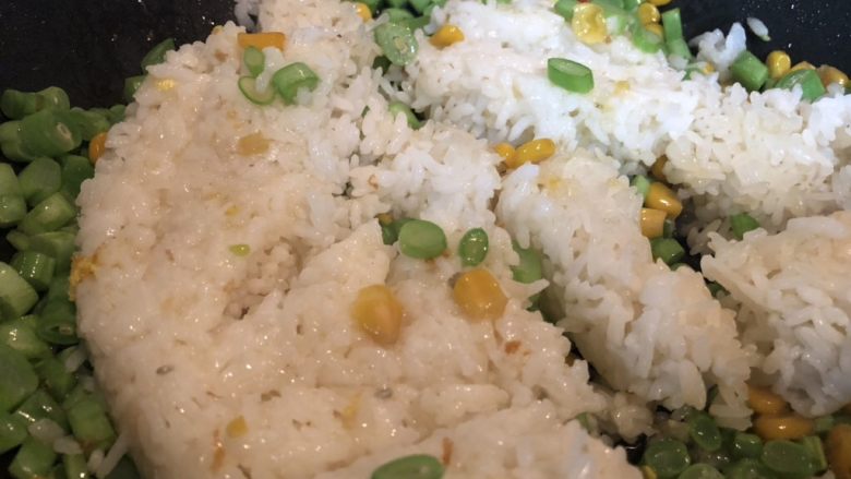 鱼米之乡蛋炒饭,炒至四季豆断生,下饭,用铲子压散饭粒,炒匀。