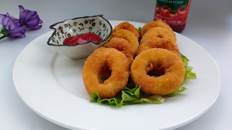 酥炸鱿鱼圈,<a style='color:red;display:inline-block;' href='/shicai/ 121'>生菜</a>切丝摆盘,放上鱿鱼圈,配上番茄即可。