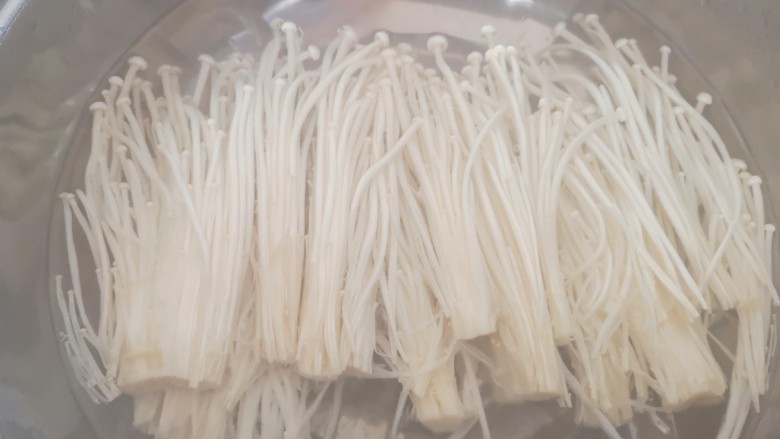 金针菇培根卷,放入沸水中焯1分钟后捞出,用冷水清洗后挤去水份