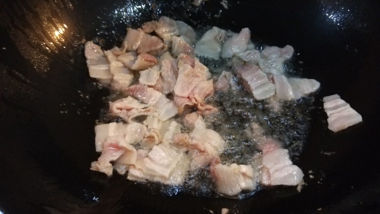 五花肉炒茭白,锅中放入适量油,倒入五花肉。