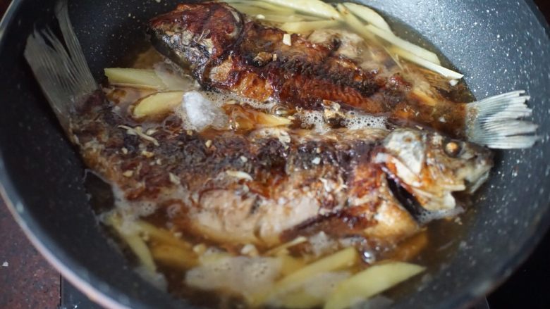 酸木瓜红烧鲫鱼,加入冰糖和美极鲜味汁,盖上锅盖大火煮开