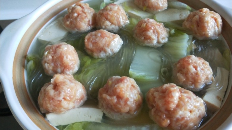 新文美食 猪肉丸子粉条煮白菜,用手挤出圆形肉丸放入锅中一起煮。