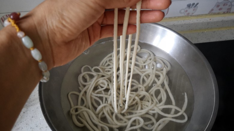 风味炒拉条子,锅中烧开水,将醒好的面拉开,拉长,下锅。(面一定要多揉多醒,醒好后再拉开,否则面会缺乏韧性、在拉的时候容易断裂。)