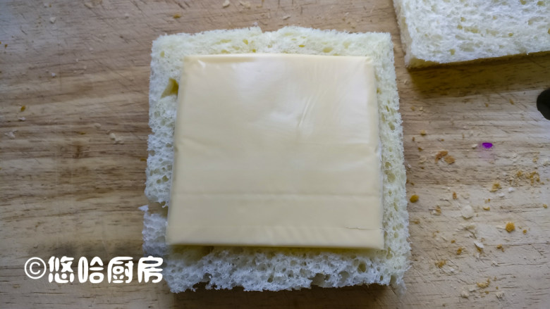 一键式白吐司&肉松三明治,盖上一片吐司,上面放芝士片,再盖上一片吐司,从对角线切开也行,从中间切开也行,根据自己的喜好来哦。