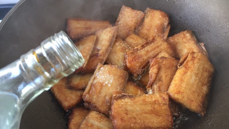 十味 家熬带鱼,沿锅沿烹入2勺料酒,去腥提鲜。