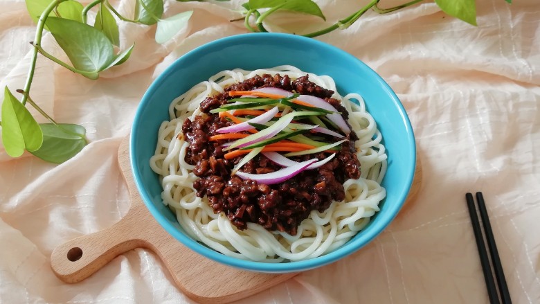 豆干炸酱面,面条盛入碗中，浇上豆干炸酱，放上黄瓜胡萝卜洋葱丝。