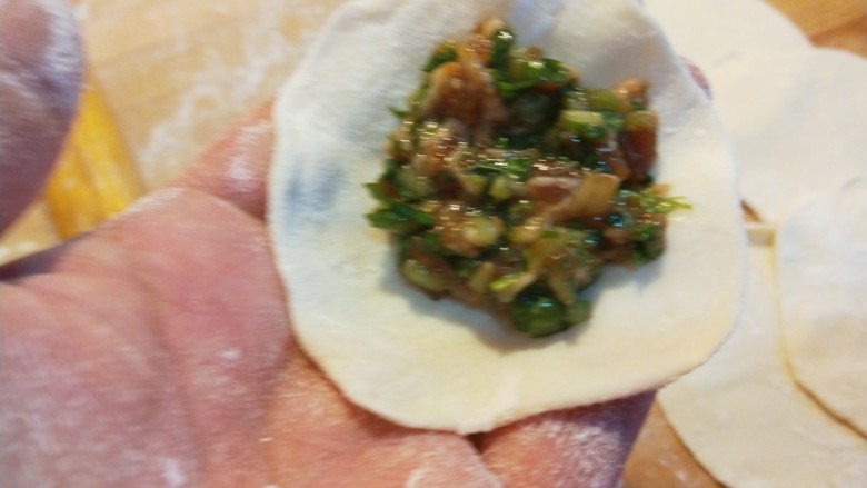新文美食 小芹菜猪肉饺子,擀成面皮包入馅料。