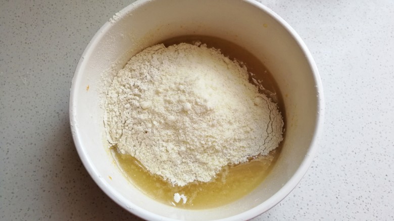 苦荞杏仁桃酥,所有粉类混合均匀,加入到玉米油混合物中,先用搅拌刀把它翻拌均匀,然后揉成面团。