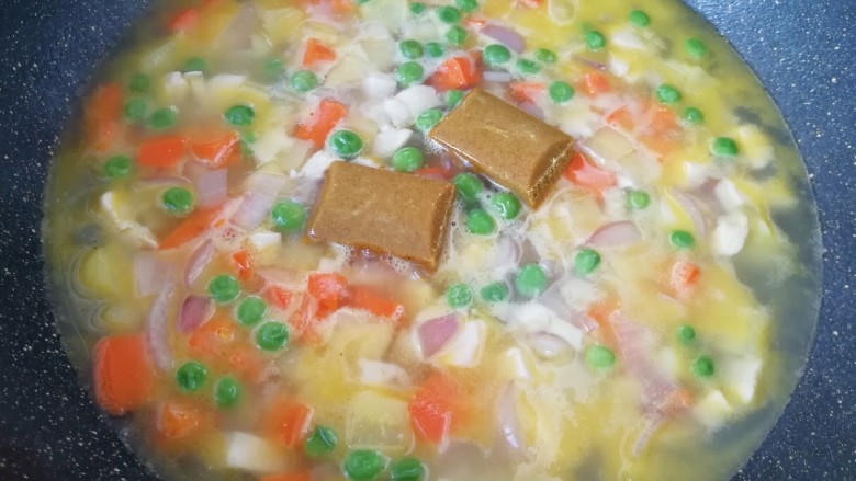 咖喱鸡肉饭,下入两块原味咖喱,用勺子搅拌均匀。