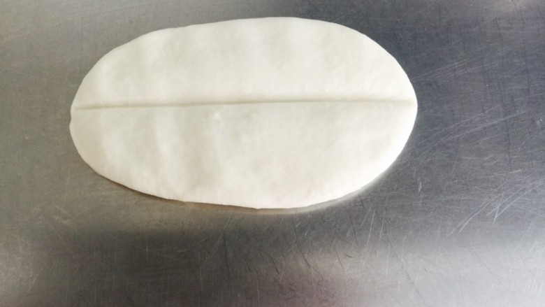 油泼面 Youpo Noodle,擀成椭圆形面皮,中间压一到。( Flatten the oval dough with a slit in the middle.)