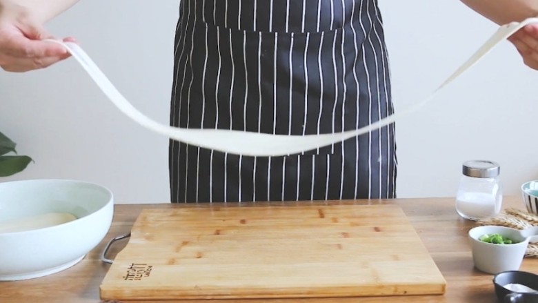 油泼面 Youpo Noodle,捏住面皮两端,轻轻的拉长。(Pinch the sides of the dough and stretch gently.)