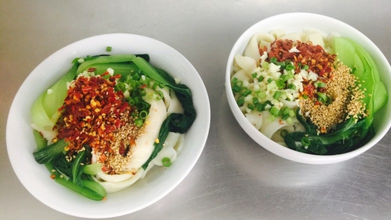 油泼面 Youpo Noodle,将油加热至8分热,淋在调好的调料上。(Pour oil into the pan and heat until boiling hot.Pour the oil into the seasoning in the bowl.)