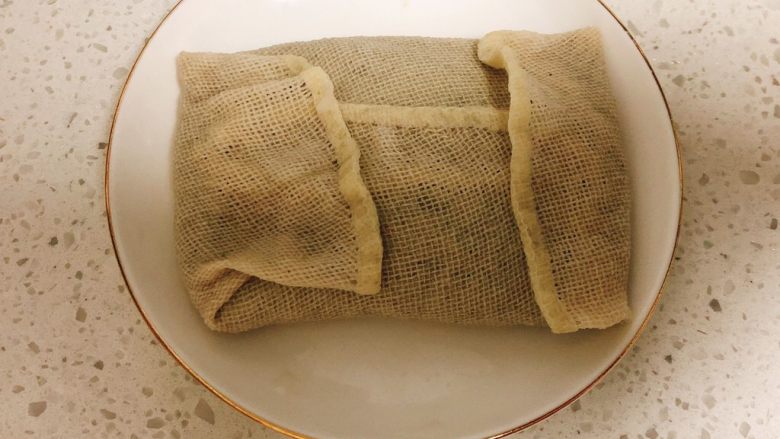 无添加自制黑豆豆腐➕葱油豆腐,将纱布折好,包裹着豆腐花。