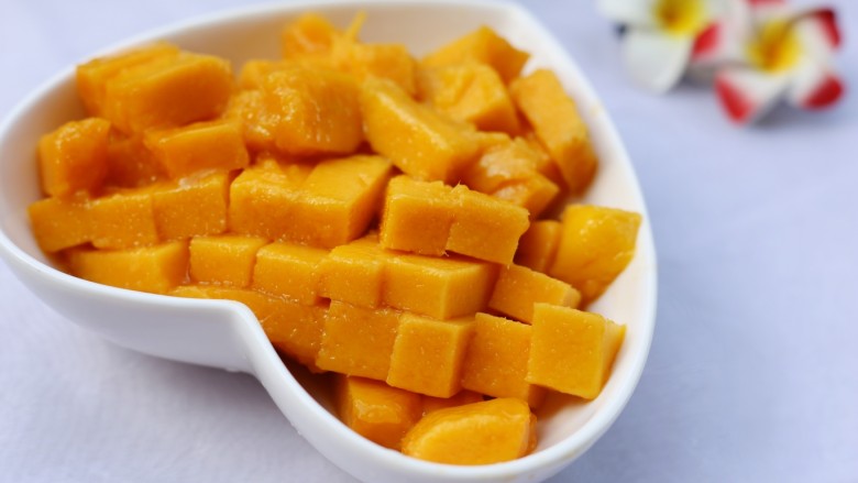 美食丨芒果牛奶汁 让宝宝舔杯的饮品～,芒果洗净去皮，切开两边，用刀在芒果横竖各切几刀，翻起果皮切出芒果丁。