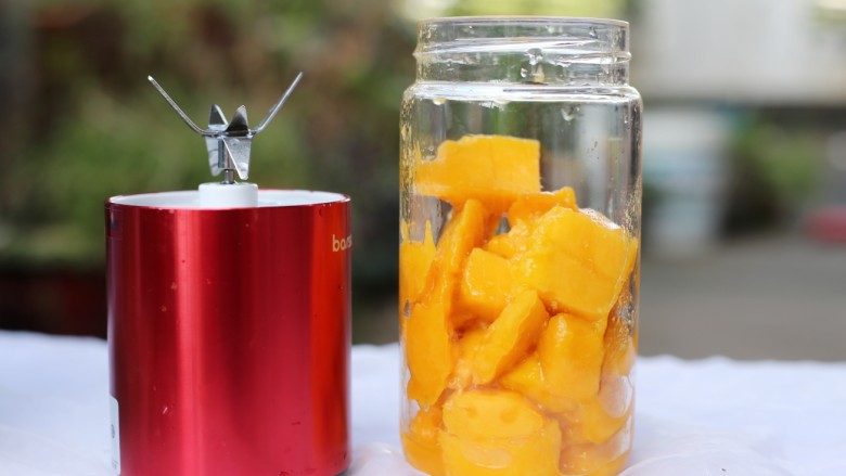 美食丨芒果牛奶汁 让宝宝舔杯的饮品～,取果汁机，将切好的芒果预留４块，其余的倒入果汁机杯中。