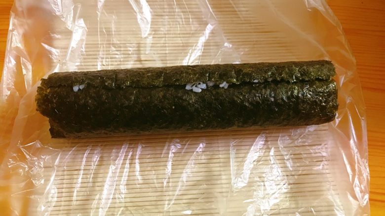 鸡肉寿司,使用竹卷卷起,压实成圆条。