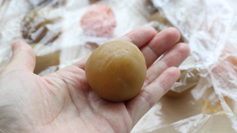 蛋黄莲蓉月饼,用虎口将莲蓉馅慢慢推上来,包裹住蛋黄,收口后搓圆备用
