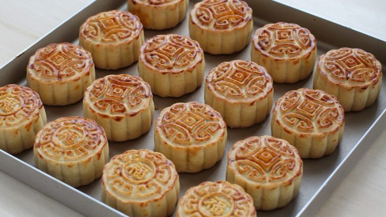 蛋黄莲蓉月饼,待月饼表面颜色变深,四周有些胀鼓取出晾凉,再密封放置两到三天,回油后即可食用