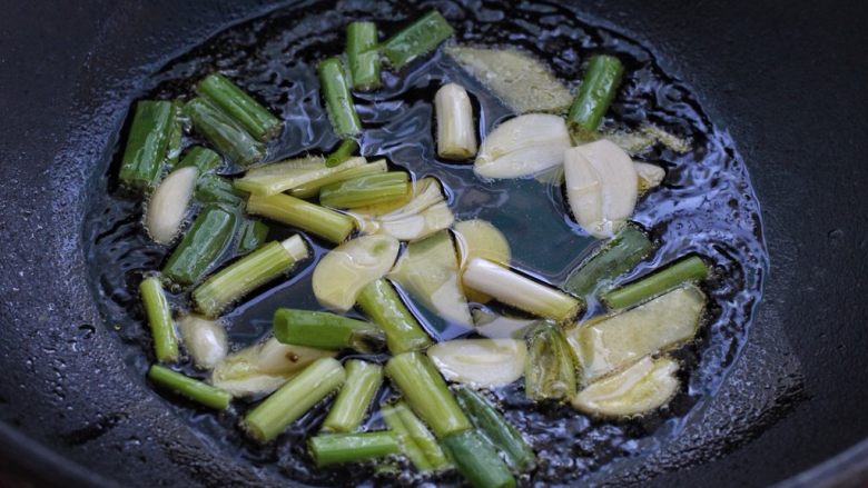 红烧鸡腿蘑菇,锅中倒适量食用油烧热,放入葱姜蒜小火炒香,为了还原本来的味道,我特意用铸铁锅来做这道菜