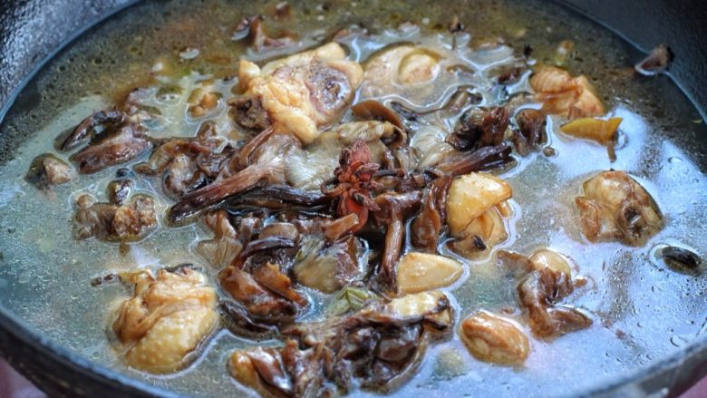 红烧鸡腿蘑菇,添入适量清水没过锅中食材,投入八角,大火煮开后改中小火炖煮20分钟