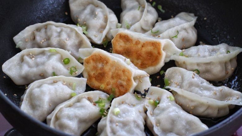 猪肉芹菜煎饺,盖上锅盖继续煎至锅内水分快干、发出噼啪的响声时,撒入适量的葱花和<a style='color:red;display:inline-block;' href='/shicai/ 666'>芝麻</a>,待饺子底部呈焦黄状关火即可