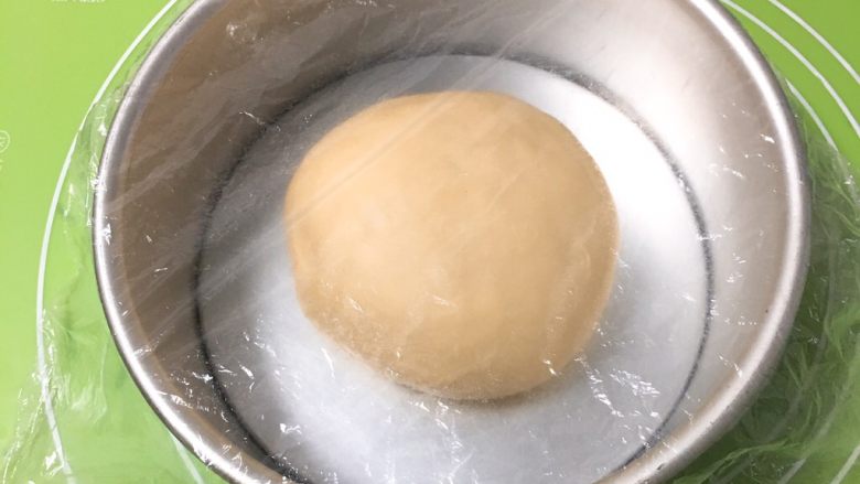 红豆奶香吐司面包,整理滚圆放入模具,盖上保鲜膜。