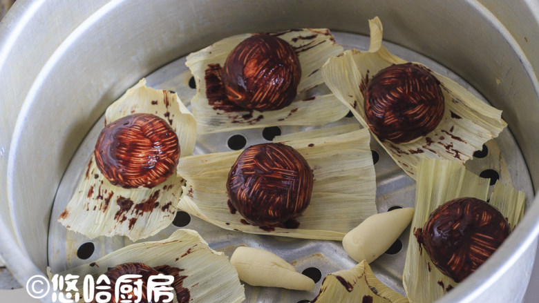 蘑菇豆沙包,在豆沙包下面垫一张油纸或玉米皮,放入蒸锅中进行醒发,醒发至面团蓬松变大,开小火蒸,蒸锅上汽后转中大火蒸15分钟即可。余下的面团分成12个,搓圆成一头细一头粗的长面团,一同摆入蒸锅中。
