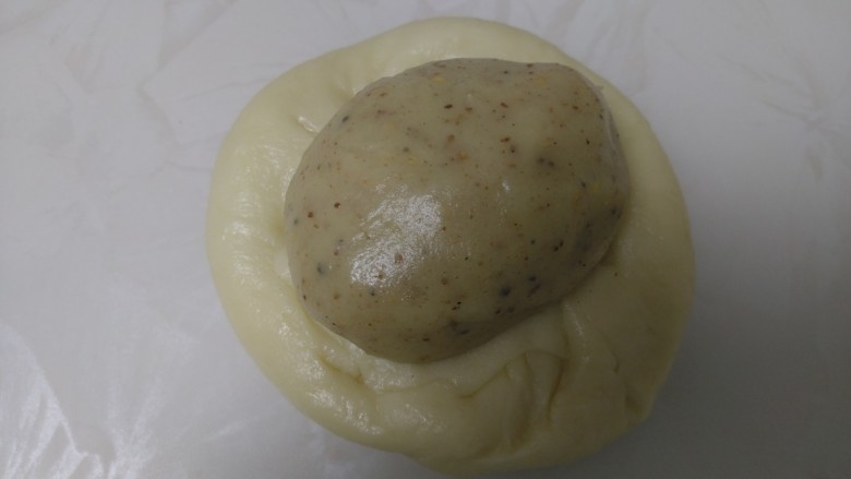 芝麻椒盐烧饼,取一个油皮用手压扁,包入油酥。