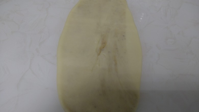 芝麻椒盐烧饼,用手压扁,从中间往上擀,再从中间往下擀。