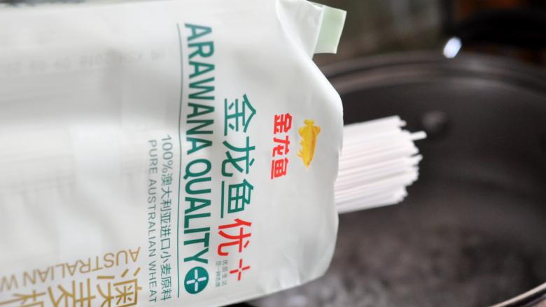 红烧鸡腿面,汤锅里的水烧开后,放入金龙鱼优+澳麦椭圆挂面。
