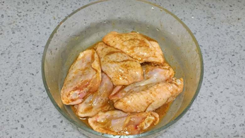 柠檬咖喱鸡翅,5、把步骤4中搅拌均匀的腌料水倒在鸡翅中,用手抓匀,放入冰箱冷藏2个小时。