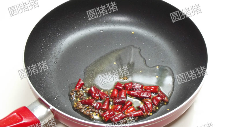 辣子鸡翅,炒锅干烧,放入洗净的干椒和<a style='color:red;display:inline-block;' href='/shicai/ 700'>花椒</a>炒至干,再加入1大匙油慢慢加热。