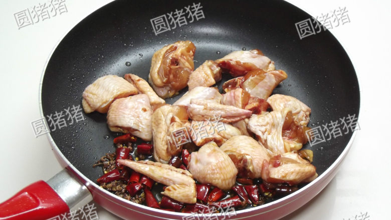 辣子鸡翅,加入鸡翅块,姜、蒜碎,用小火煸炒出油。