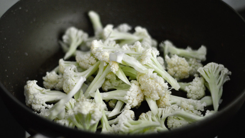 干煸菜花,锅里再次倒入少许油,烧热后放入菜花煸炒