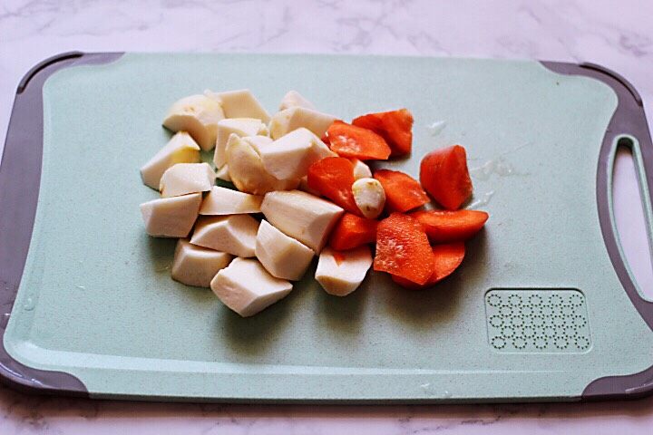 十味 超美味的咖喱芋头鸡肉饭,把洗净的芋头和<a style='color:red;display:inline-block;' href='/shicai/ 25'>胡萝卜</a>用刀切成滚刀块备用。