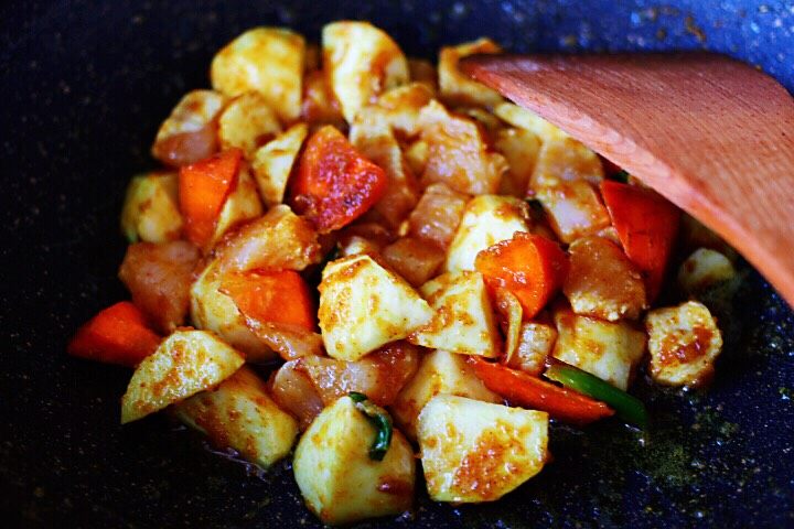 十味 超美味的咖喱芋头鸡肉饭,继续用锅铲慢慢翻炒片刻,看见鸡脯肉块炒至变色的时候。