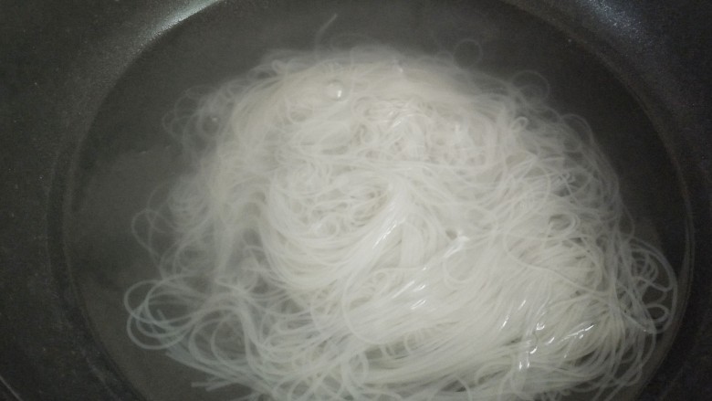 鸡蛋炒粉丝,把锅里坐水烧开,下泡好的粉丝焯水一分钟,赶紧捞出来平摊备用