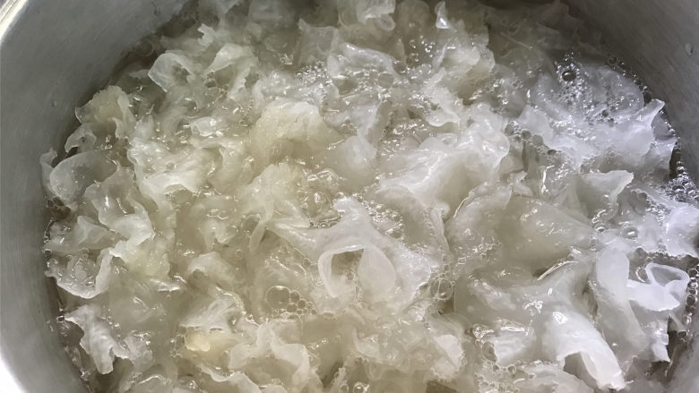 蔓越莓桃胶银耳羹,把泡发清洗干净的银耳放入砂锅,加上适量的水。