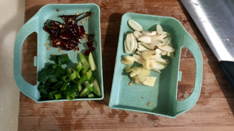 绿叶丛中睡一场➕私房农家小炒肉,全部食材清洗后开始改刀:蒜切蒜片,姜切姜片,小葱切细斜段,干辣椒剪刀剪成细丝