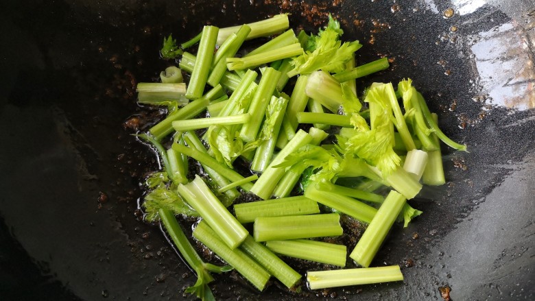 十味 客家小炒,锅中留底油，下入芹菜段翻炒。