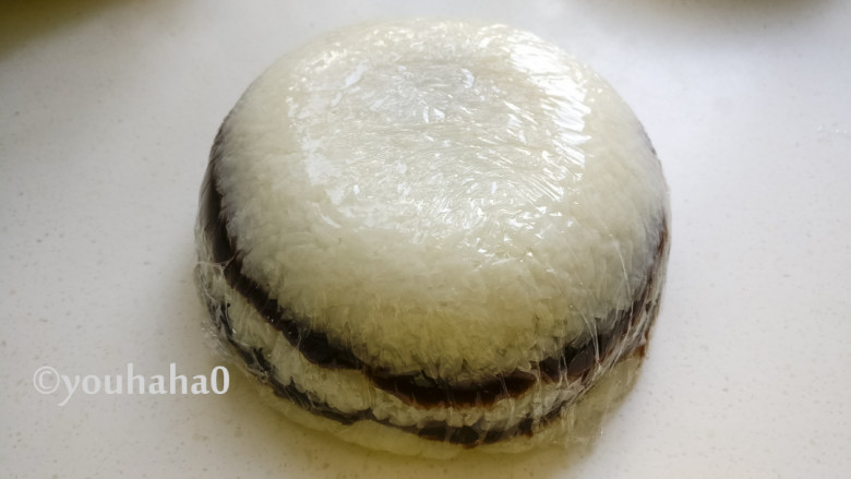 糯米红豆糕,最后铺上一层糯米饭,用保鲜膜包好,倒扣出来就是一个糯米红豆糕。