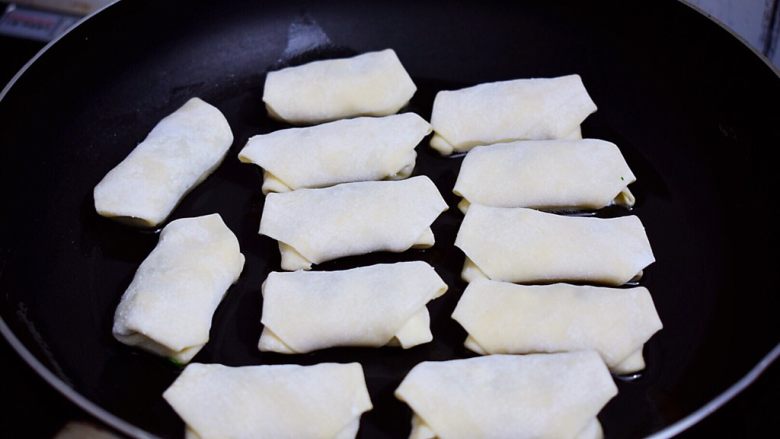馄饨皮韭菜盒子,锅中倒入适量的食用油烧热,放入韭菜盒子