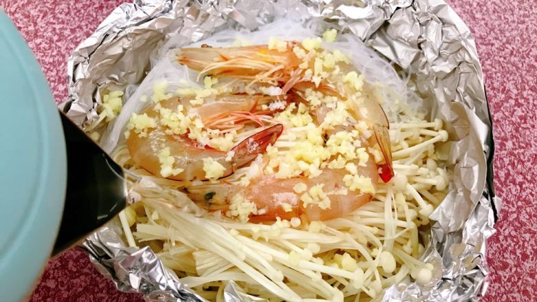 锡纸金针菇粉丝虾煲,兑入适量开水。因为粉丝比较吸水,所以要兑入开水。