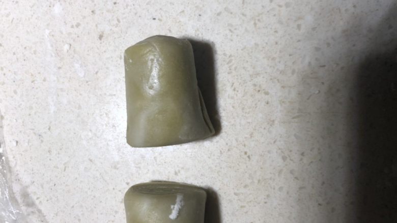 抹茶绿豆蛋黄酥,去醒好的面卷,从中间切开。
