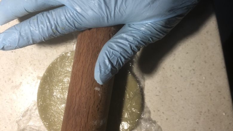 抹茶绿豆蛋黄酥,盖上保鲜膜擀薄。