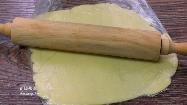 炼乳脆饼干,将面团装入保鲜袋内,用擀面杖擀成厚度约0.3-0.4cm 的薄片;
