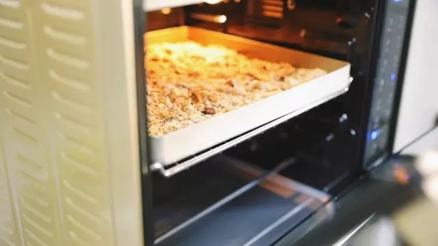 自制谷物麦片,烤箱150度先预热10分钟,预热好继续150度放中层上下火烤15分钟,中途拿出来翻拌一下再继续烤,这样能烤的更均匀