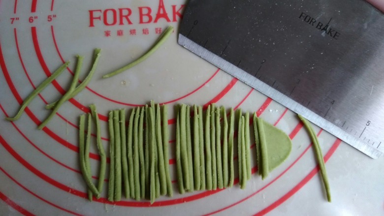 象形胡萝卜馒头,绿色面团擀成薄面片,用法焙客切面刀切出若干条细小的面条。
