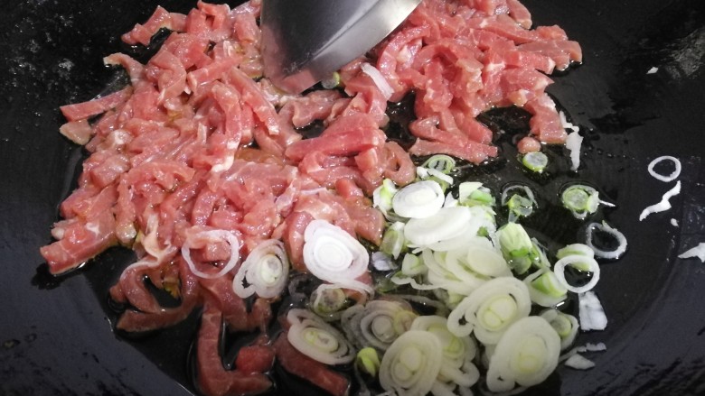 家常菜~牛肉炒大青椒,放入葱片,牛肉条。