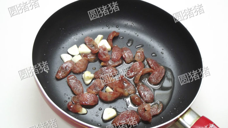 腊肠炒蒜苔,锅内放1小匙油,冷油放入腊肠片及蒜蓉小火煸炒至腊肠转红色,盛出备用。